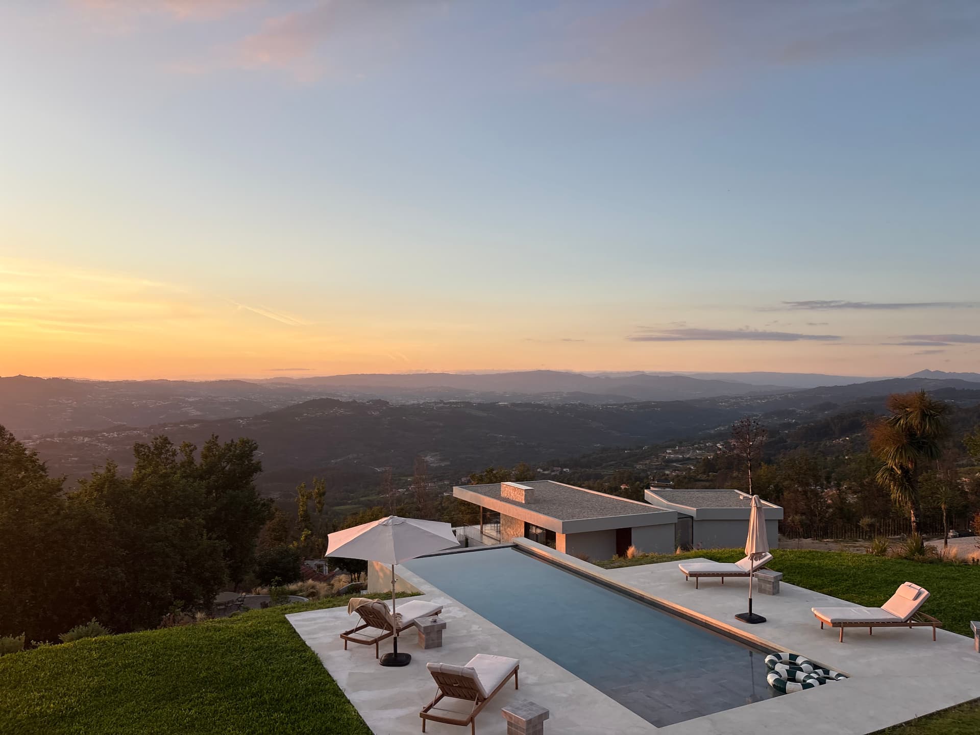 Infinity pool and villa at golden hour above the valley